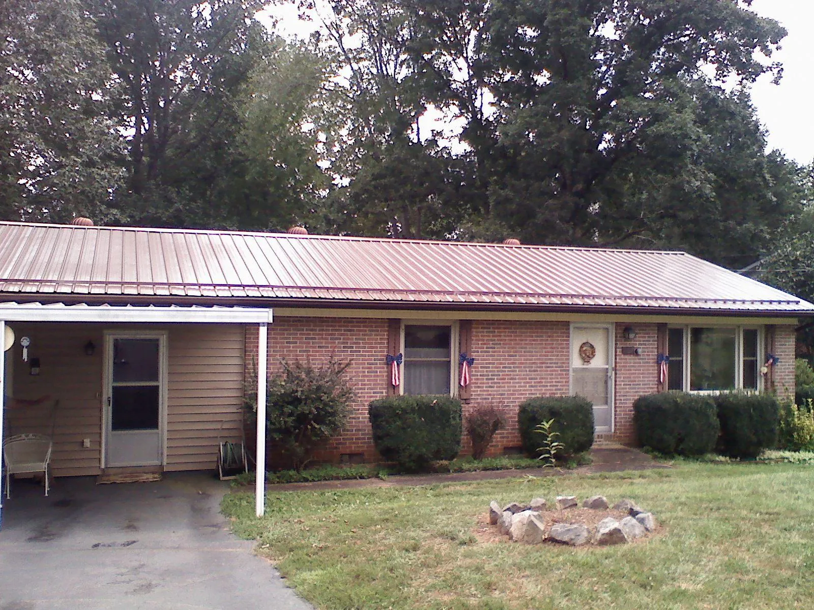 Bronze metal roof and carport on a brick ranch home — Roof Repair work by our crew in Burnham