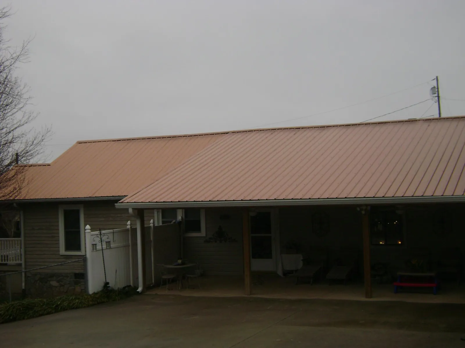 Copper toned metal roof over a wide covered patio in Burnham